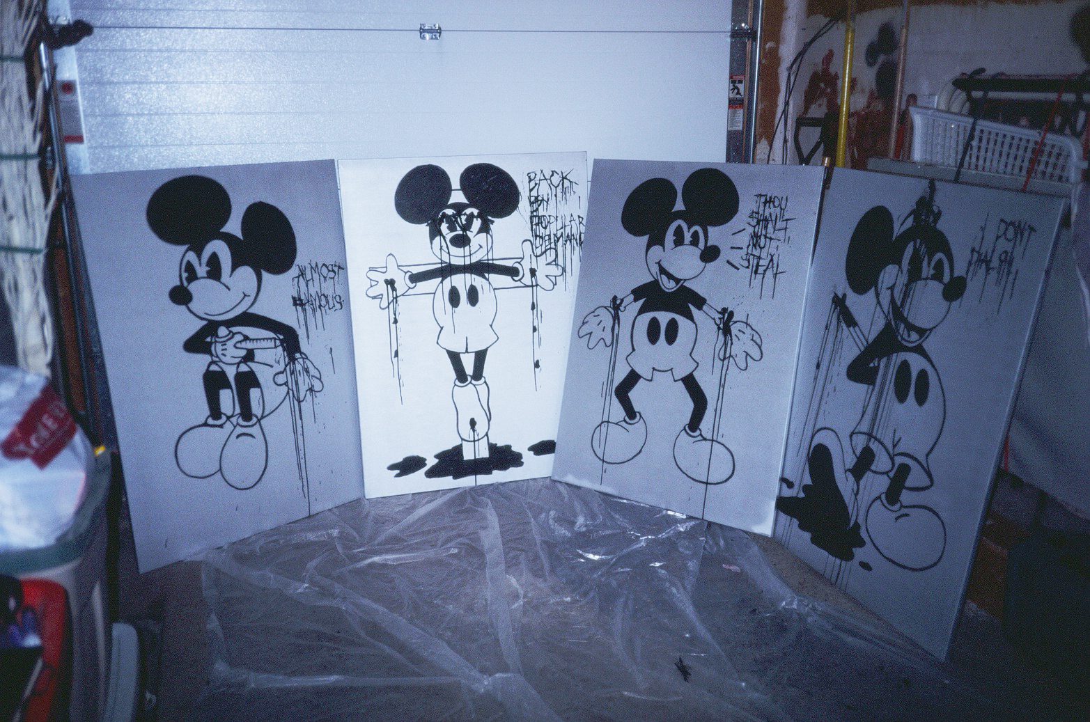 Four Matt Adam Mickey Mouse paintings in black ink, with hand-lettered slogans