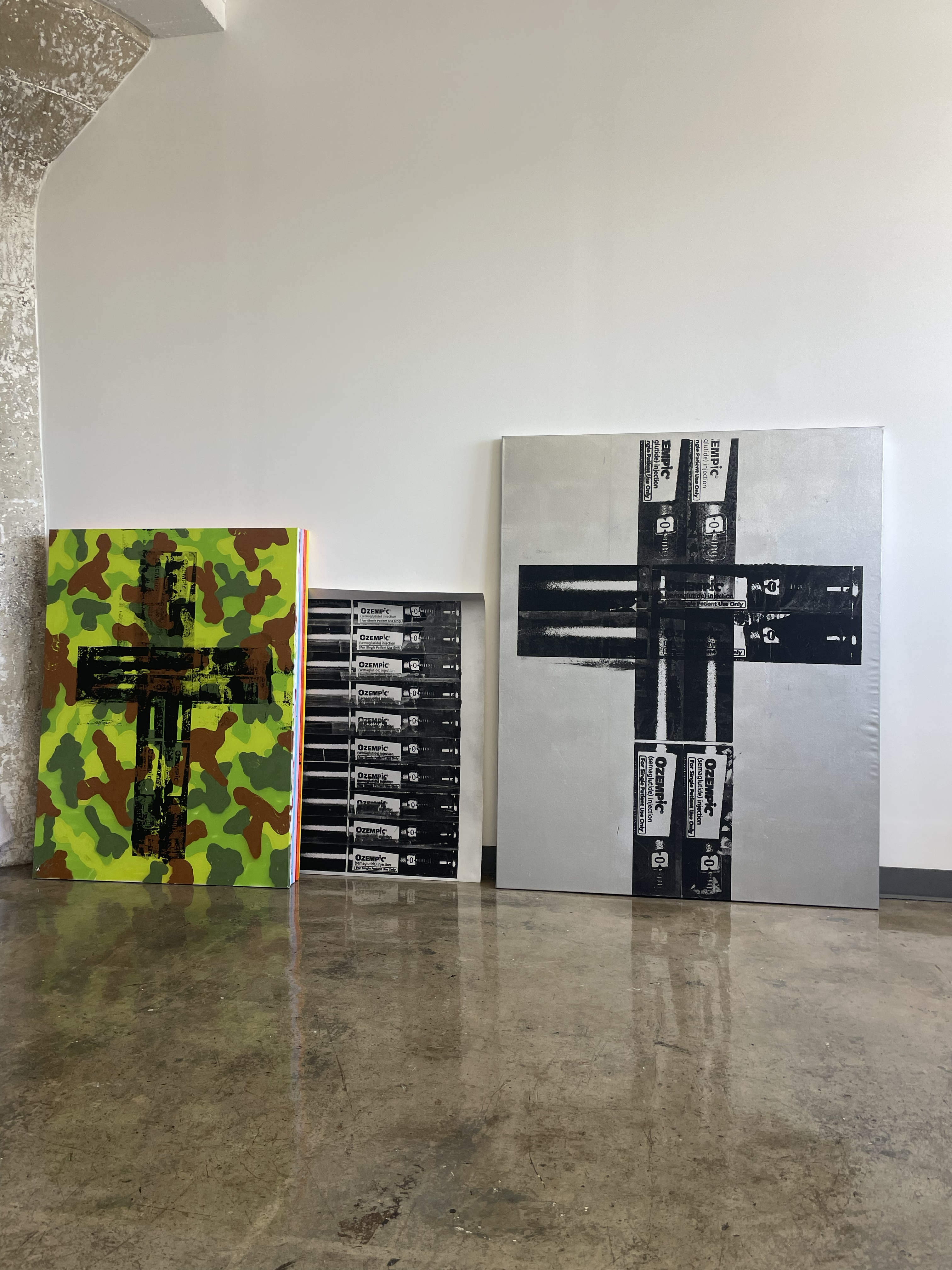 Group of Matt Adam Ozempic cross paintings in the studio